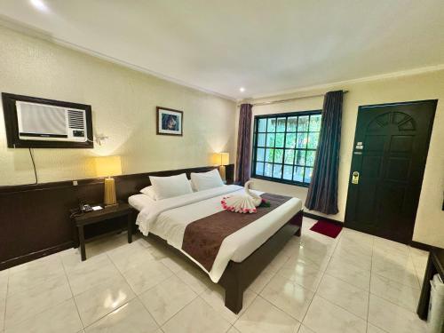 a bedroom with a large bed and a large window at Casa Pilar Beach Resort in Boracay