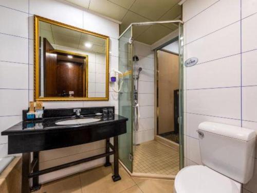 a bathroom with a sink and a shower and a toilet at Zhongshan Hui Quan Hotel in Zhongshan