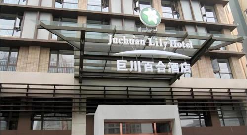 a building with a sign on the side of it at Tianjin Juchuan Lily Hotel in Binhai