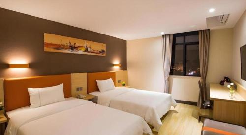 a hotel room with two beds and a window at IU Hotel Chengdu High-Tech Zone Longhu Times Street in Chengdu