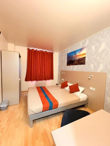 a bedroom with a bed with a red curtain at Hotel de Normandie in Gournay-en-Bray