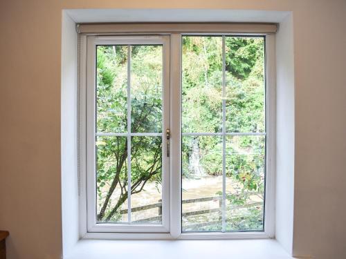 an open window with a view of a garden at Riverside Cottage in Keswick