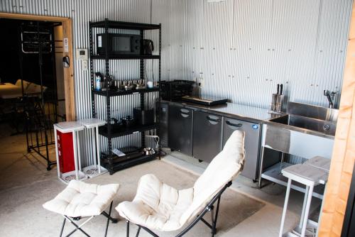 a kitchen with two white chairs and a sink at Rockstar Villa 江井浜STYLE in Awaji