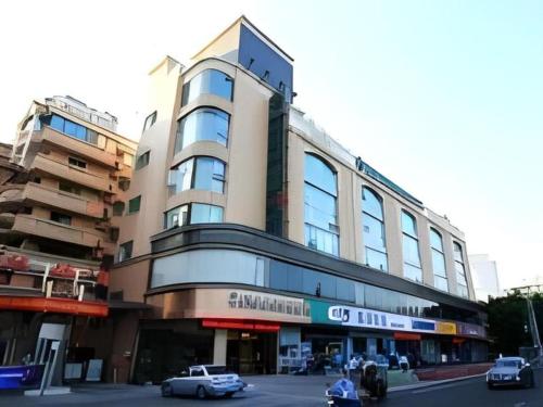 a large building with cars parked in front of it at GreenTree Inn Fuzhou Gulou District West Xierhuan Road Zuohai Park in Fuzhou