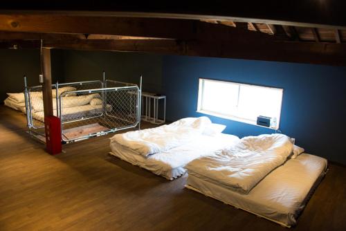 two beds in a room with a blue wall at Rockstar Villa 江井浜STYLE in Awaji