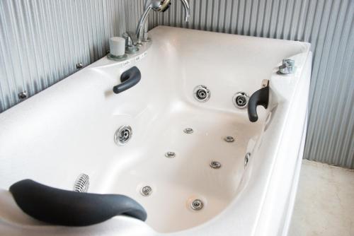 a white bath tub with a black whale sitting in it at Rockstar Villa 江井浜STYLE in Awaji