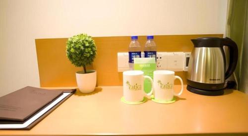 a desk with two coffee mugs and a coffee maker at Vatica Beijing Tongzhou Liyuan Universal Studios in Beijing