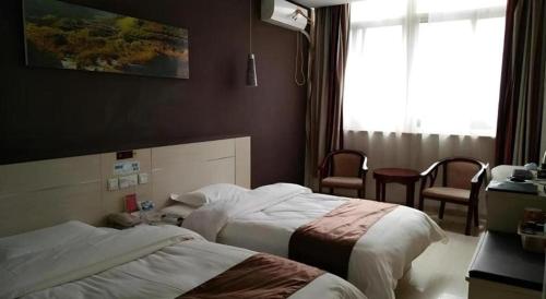 a hotel room with two beds and a window at Thank Inn Hotel He'nan Xinxiang Changyuan Bo'ai Road in Changyuan