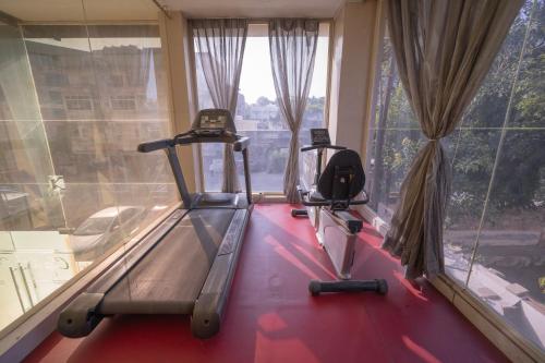 two exercise machines in a gym with windows at Hotel Clarks Collection Bhavnagar in Bhavnagar