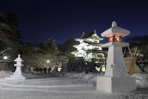 a large white building with a clock tower at night at プレジール弘前101 in Hirosaki