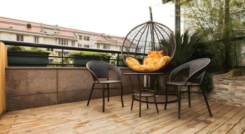 a table with chairs and a bird cage on a balcony at Shell Shanghai Jiading Nanxiang Town Minzhu Street Hotel in Shanghai