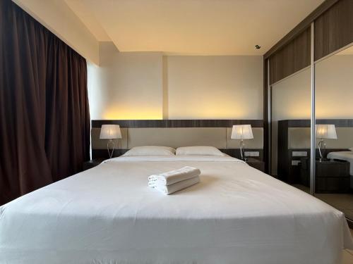 a large white bed with a white towel on it at QUINCE HOME GRAND ION DELEMEN GENTING HIGHLANDs in Genting Highlands