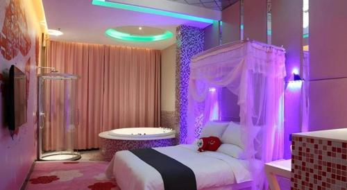 a bedroom with a bed and a tub with purple lights at Thank Inn Plus Jiangsu Taizhou Renmin Hospital in T'ang-wan-chen