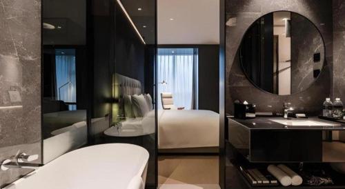 a bathroom with a bed and a sink and a mirror at Twinkle hotel Hangzhou in Hangzhou
