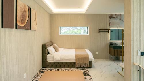 a bedroom with a bed and a window at Eudaimonia Poolvilla Jeju 에다모니아 함덕풀빌라 in Jeju
