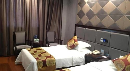 a hotel room with two beds and two chairs at GreenTree Inn Wuxi Xinwu District Meicun Town Taibo Avenue in Wuxi