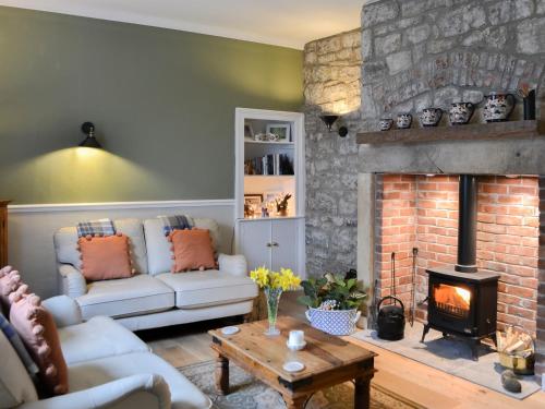 a living room with a couch and a fireplace at Conway - Cottage in Rothbury