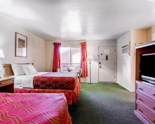 a hotel room with two beds and a flat screen tv at Econo Lodge Inn & Suites in Durango