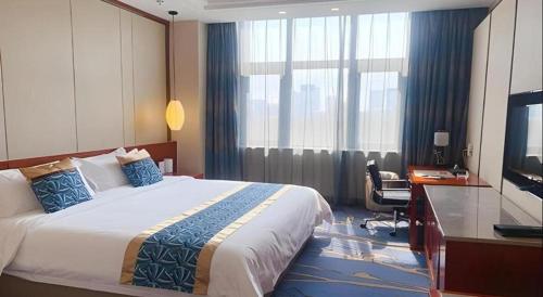 a hotel room with a bed and a desk and a television at YUN-RAY Hotel Shijiazhuang in Shijiazhuang