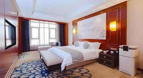 a bedroom with a large bed in a room at YUN-RAY Hotel Shijiazhuang in Shijiazhuang