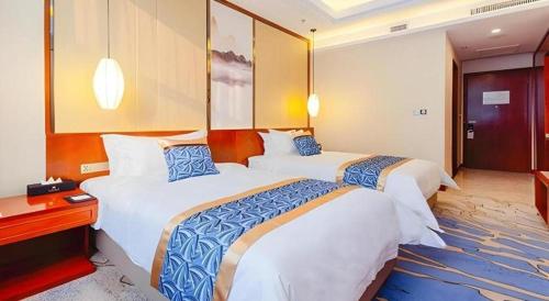 a hotel room with two beds in a room at YUN-RAY Hotel Shijiazhuang in Shijiazhuang