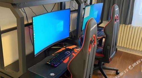 a desk with two computer monitors and a keyboard at Jinjiang Inn Qingdao Wuxi Square Nanjing Road Metro Station in Qingdao