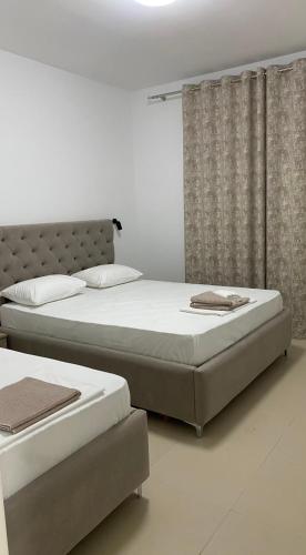 two twin beds in a bedroom with curtains at Apartments Drini in Ulcinj