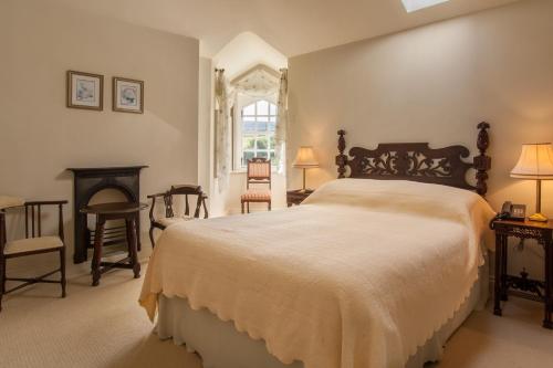 een slaapkamer met een groot bed en een open haard bij Stella Maris Shore House in Ballycastle