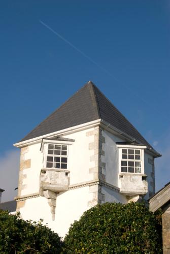 a white house with two windows and a black roof at Stella Maris Shore House in Ballycastle