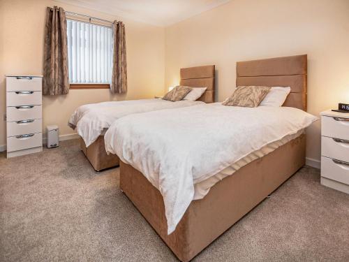 a bedroom with two beds and a window at Terra Verde in Beauly