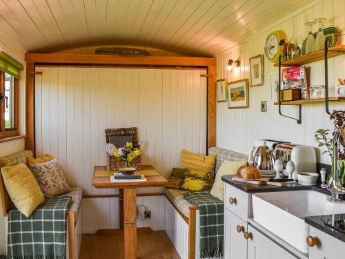 a kitchen with two couches in a tiny house at Shepherds Hut - Ukc6774 in Llanallgo
