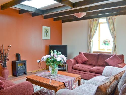 a living room with a couch and a table at Burns Cottage in Drumnadrochit