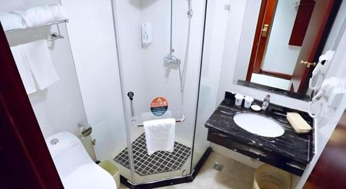 a bathroom with a shower and a toilet and a sink at GreenTree Inn Heze Mudan Road Bus Terminal Station Express Hotel in Heze