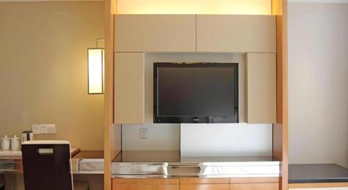 a living room with a flat screen tv on a wall at Nanning Prince Hotel in Nanning