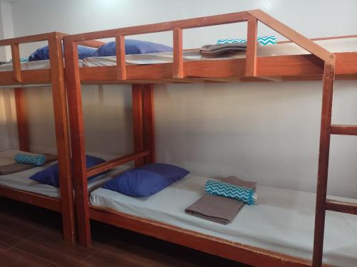 a bunk bed in a hostel with a white bed at Angler's Hub & Resort Oslob in Oslob