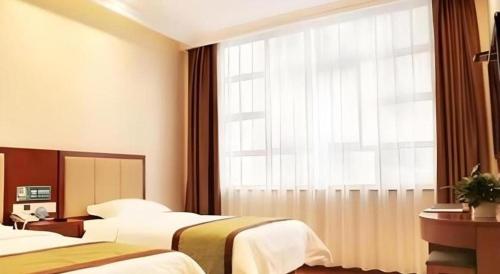 Ένα ή περισσότερα κρεβάτια σε δωμάτιο στο GreenTree Inn HanZhong Railway Station Beiyihuan Road Express Hotel