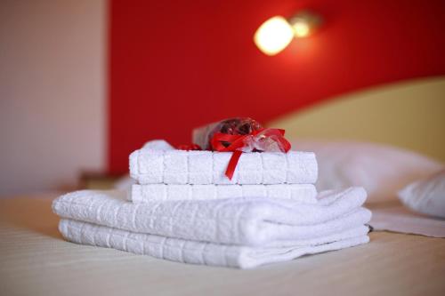 a stack of towels sitting on top of a bed at Rooms & Apartments Soline Nuove in Biograd na Moru