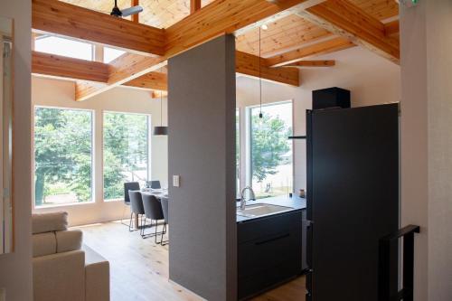 a kitchen and dining room with wood ceilings at White Sierra Chalet in Hakuba