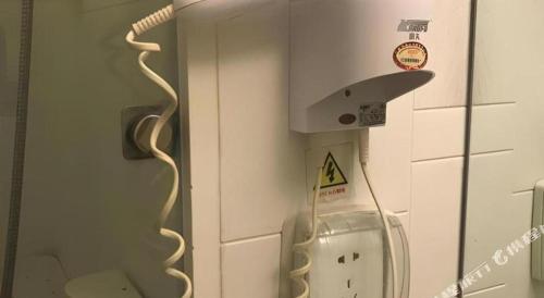 a telephone in a room with a sign on the wall at 7 Days Inn Qingdao Liaoyang West Road Xinye Plaza Metro Station in Qingdao