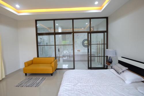 a bedroom with a bed and a yellow chair at Bali hotel 