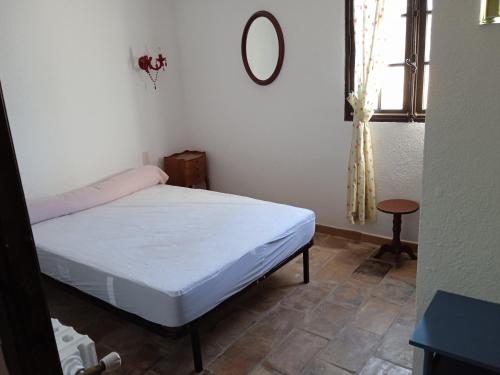 a bedroom with a bed and a mirror and a window at Charmant maset provençal in Montmeyan