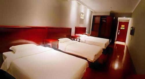 a hotel room with three beds in it at GreenTree Inn Suzhou Shihu Suli Road Express Hotel in Suzhou