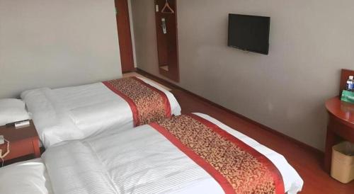 a bedroom with a white bed with a couch and a tv at GreenTree Inn Suzhou Shihu Suli Road Express Hotel in Suzhou