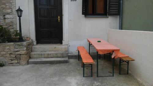 an orange table and two chairs in front of a door at Holiday Home Angela in Medulin