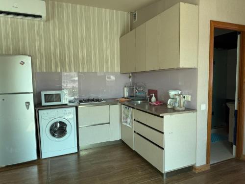 a kitchen with a refrigerator and a washing machine at Bright Guesthouse in the center of Yerevan! in Yerevan