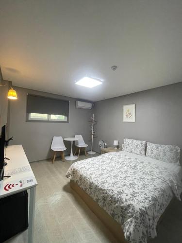 a bedroom with a bed and a table and chairs at Gyeongju BonghwangMansion in Gyeongju