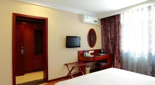 a bedroom with a bed and a tv and a window at GreenTree Inn Hefei Chenghuangmiao San Xiao Kou Subway Station Hotel in Hefei