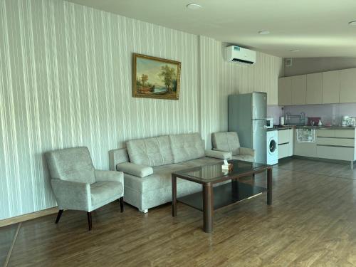 a living room with a couch and a table and a chair at Bright Guesthouse in the center of Yerevan! in Yerevan