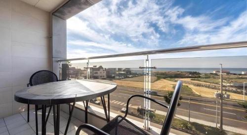 a balcony with a table and a view of a highway at Sea View Hotel in Jeju