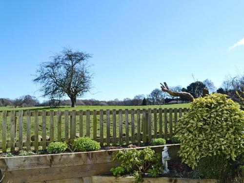 a wooden fence with a garden in a park at The Beehive in Betley